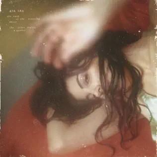 Pochette de one hand on the steering wheel the other sewing a garden – Ada Lea